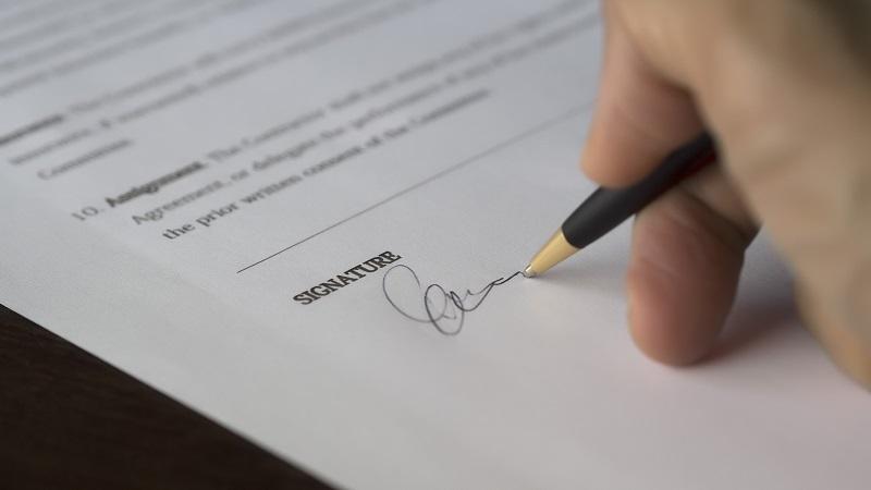 An image of a contract being signed